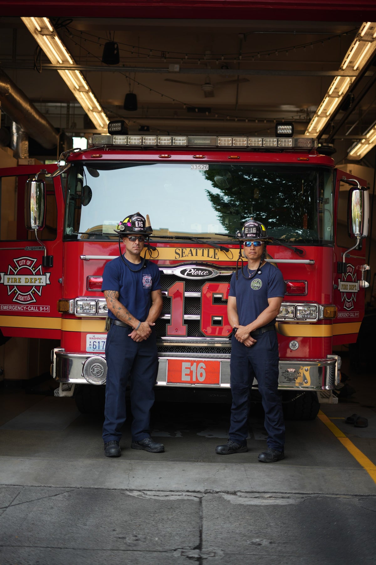 Two firefighters wearing Torque sunglasses in the open fire station bay