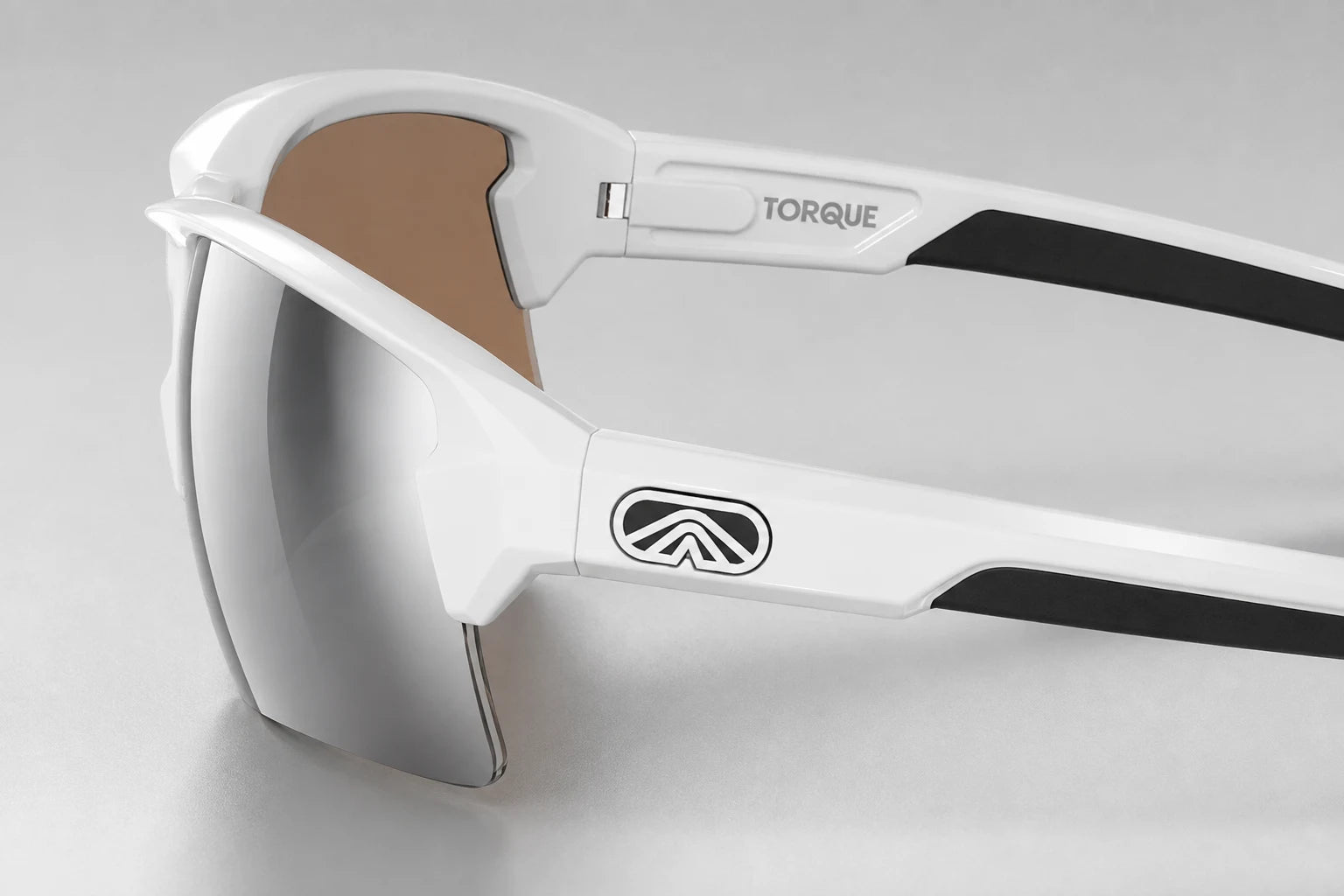 Close side view of white Camber sunglasses with polished silver lenses, both open temples and Torque markings on pearl gray